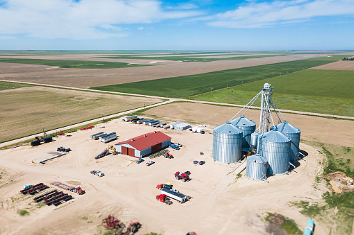 Drone shot of american farmland, machinery storage and grain silos
