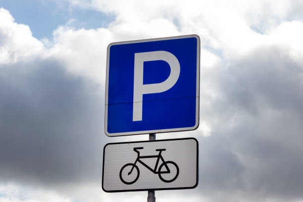 istock Parking bicycle sign on dull gray sky background 1181507339