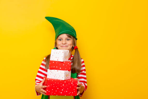 istock Child dressed as Santas helper holding Christmas presents 1181508295