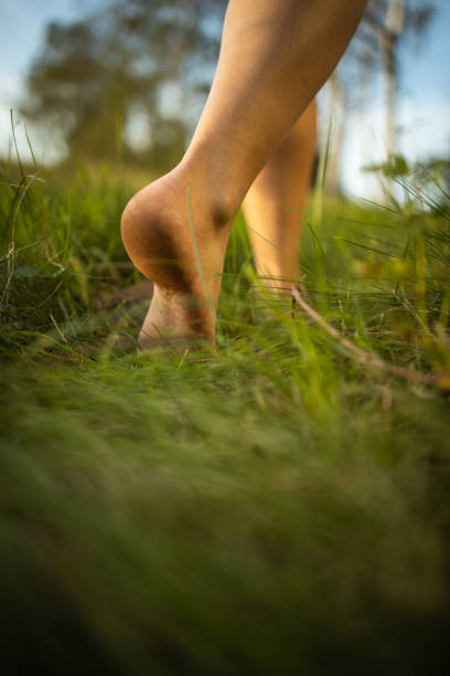 istock Barefoot young woman in green meadow 1181508336