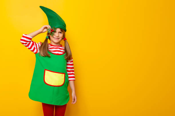 istock Child wearing elf costume holding mistletoe 1181508348