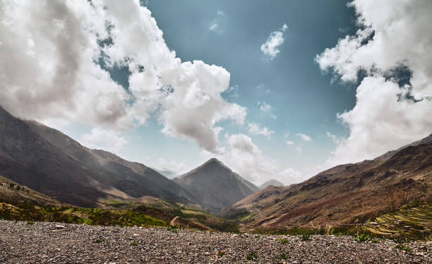 Panoramic view of Tacheddirt valley and mountain with double peaks, volcano evaporating clouds from the caldera in High Atlas mountains Morocco Africa