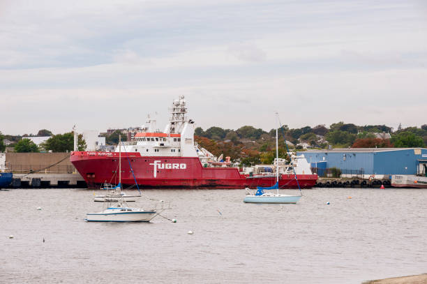 barche a vela ormeggiate vicino alla nave da rilevamento fugro searcher - searcher foto e immagini stock