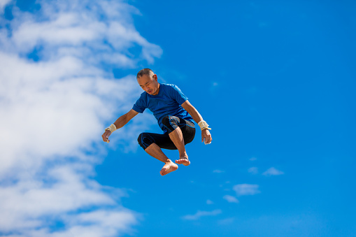 Trapeze artist flying in the blue sky