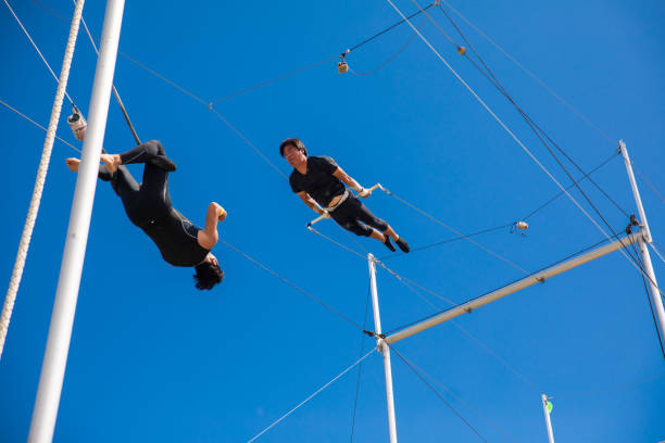 Trapeze artists jumping to the other side in the sky Trapeze artists jumping to the other side in the sky broad catch stock pictures, royalty-free photos & images