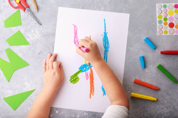 istock Child draws a pencil drawing empty space colorful grey background top view 1181520078
