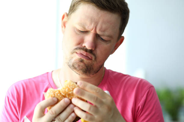 istock Unhappy bearded man looking at burger with suspicious 1181522311