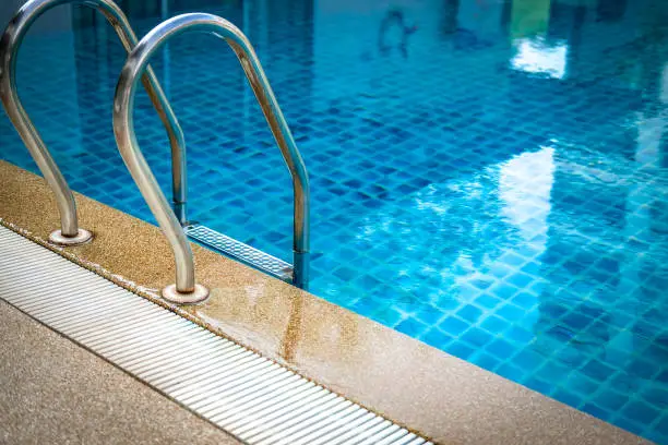 metal steel handle at edge poolside of swimming pool in hotel resort