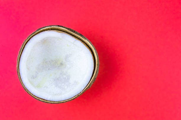 istock ugly food. old split coconut on a red background 1181530646