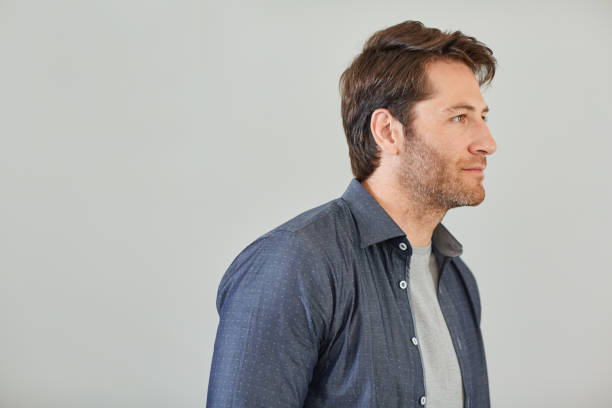 istock Smiling man deep in thought against a gray background 1181530933