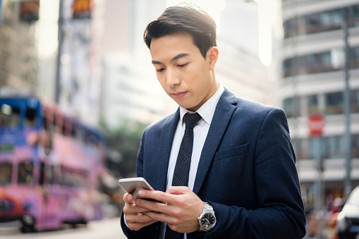 Young Asian businessman using his smartphone.