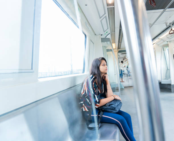 Young beautiful girl traveling by metro train Indian teenager girl travelling in Delhi metro train. outdoor shoot. delhi metro stock pictures, royalty-free photos & images