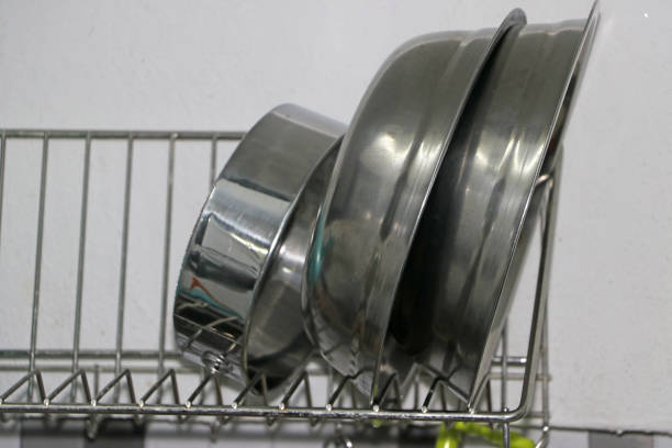 Basin and stainless steel kitchen appliances placed on the dish drainer in the kitchen.