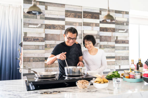 pareja china cocinando en la cocina - cooking senior adult healthy lifestyle couple fotografías e imágenes de stock