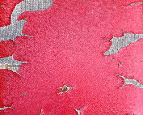 Old dirty artificial red leather texture with ripped patterns for background