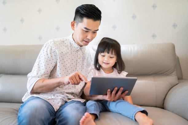 istock Asian father and daughter using a digital tablet 1181540509