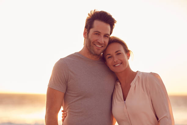 istock Loving couple standing together on a beach at sunset 1181544439