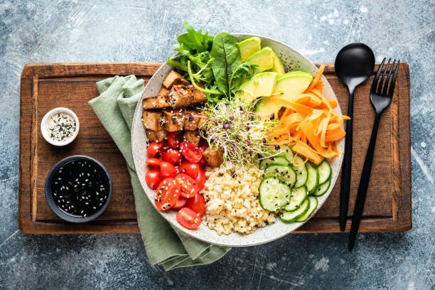 Buddha bowl with tofu Buddha bowl with tofu, avocado, bulgur grains, cucumber, carrot and tomato garnished with seeds and micro greens. Healthy vegan and vegetarian food, tasty lunch or meal. Top view salad bowl salad bowl stock pictures, royalty-free photos & images