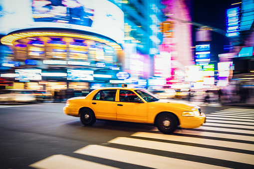 Yellow cab speeding through Midtown Manhattan.