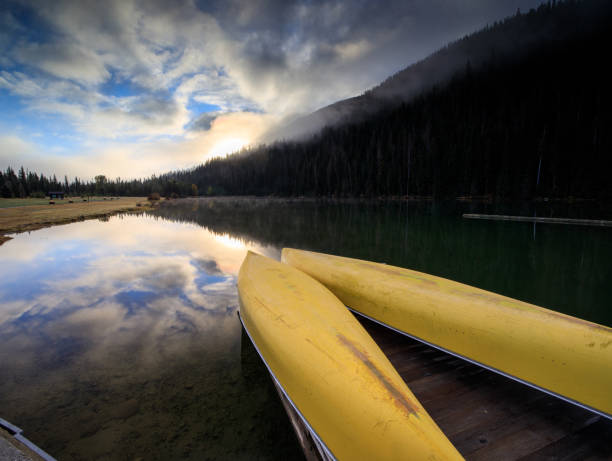 istock Yellow canoes rest on lake on a beautiful October morning 1181551402