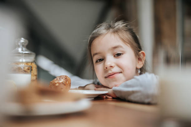 istock Cute little girl during breakfast time at dining table. 1181555782