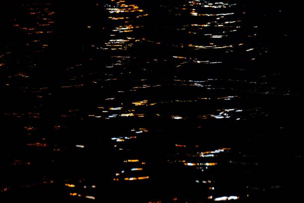 istock Blurred colorful light on river surface with water waves in the dark night 1181555903