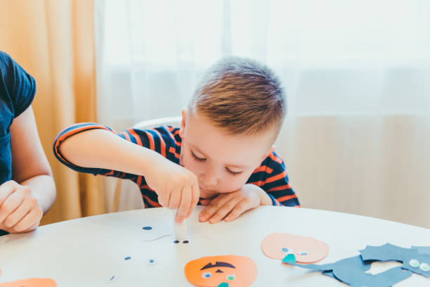 istock little boy making pumpkins head from paper halloween holidays 1181556624