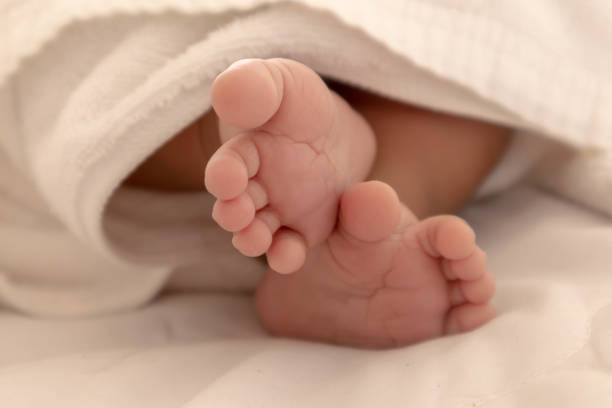 i piedi di un neonato a pochi mesi che dorme comodamente sul materasso bianco durante la buonanotta, il cervello del bambino funzionerà. migliorare le capacità di potenziamento della memoria e di apprendimento - comfortably foto e immagini stock