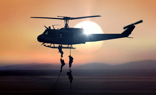 l'hélicoptère de commandos tombe pendant le lever du soleil - rappelling photos et images de collection