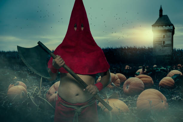 Executioner with big axe Executioner wearing red cap standing in front of field of pumpings executioner stock pictures, royalty-free photos & images