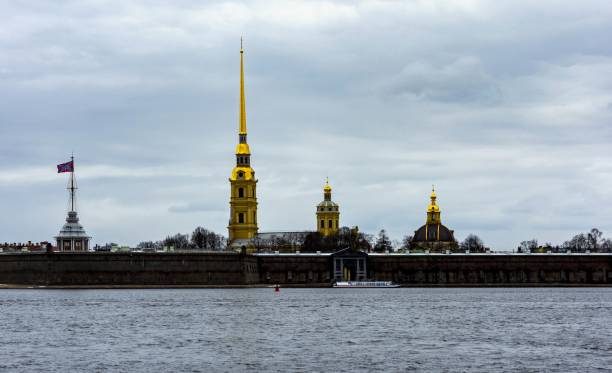 St. Peter and Paul Forteress on Neva River in St. Petersburg, Russia St. Petersburg, Russia, April 16, 2017: St. Peter and Paul Forteress in cold weather, even when it is spring. With the cathedral of the same name, where the Russian tsars are buried. The forteress is an UNESCO World Heritage Site. peter and paul cathedral st petersburg stock pictures, royalty-free photos & images