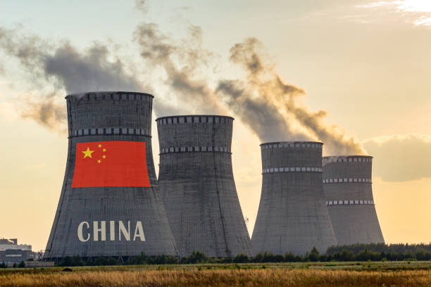 дымоходы атомных электростанций, отображающие флаг китая с согласно тексту. несчастные случаи с загрязнением окружающей среды в стране ко� - environment risk nuclear power station technology стоковые фото и изображения