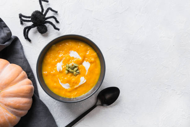 istock Halloween Pumpkin soup with cream on grey stone background. Copy space. Top view. 1181570644