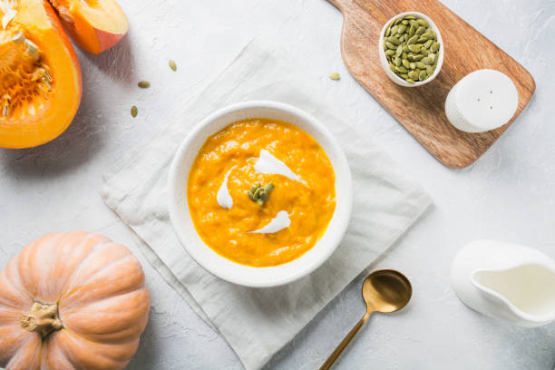 istock Pumpkin soup with cream on grey stone background. Copy space. Top view. 1181570770