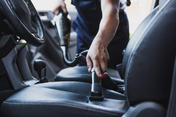 cropped view of car cleaner vacuuming drivers seat in car stock photo