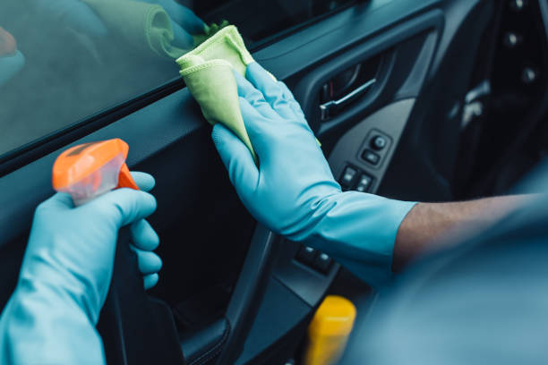 cropped view of car cleaner holding rag and spray bottle while cleaning car door cropped view of car cleaner holding rag and spray bottle while cleaning car door car door photos stock pictures, royalty-free photos & images