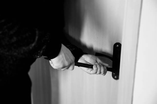 istock Criminal with crowbar near the doors. Robber breaking into house. 1181581731