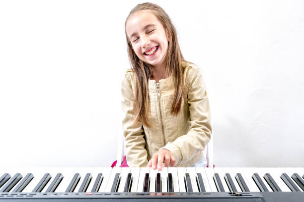 Young Girl Student at Piano Lesson Young Girl Student at Piano Lesson girl playing piano stock pictures, royalty-free photos & images