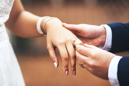 Cropped shot of an unrecognizable bridegroom putting a ring on his bride's finger on their wedding day