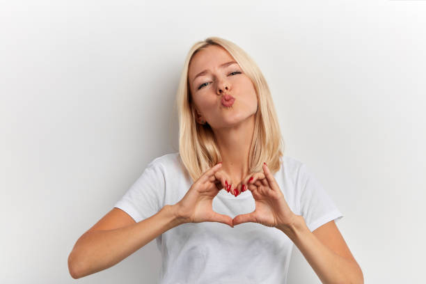 istock charming woman making heart from palms and looking at camera. 1181588692