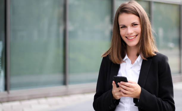 istock Smiling businesswoman using a smartphone outdoor 1181589029
