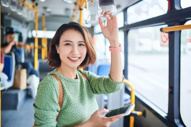 Photo of Beautiful young asian woman who see a smart phone in city bus