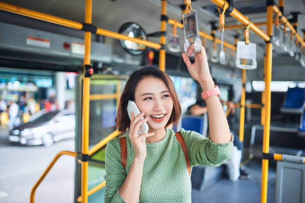 istock Smiling Woman Talking On Phone in Bus 1181589131