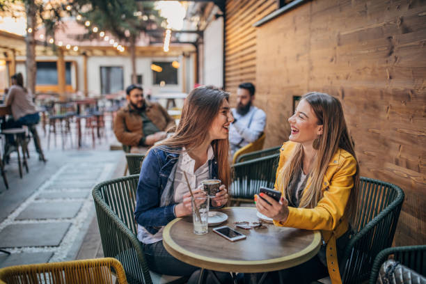 istock Young ladies sitting outdoors in cafe 1181590249