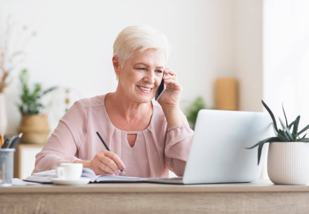 istock Smiling elderly lady talking to business partners 1181590348