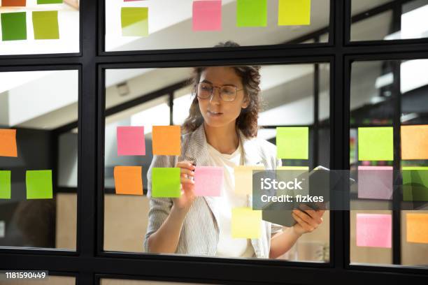 Businesswoman Creates Priority Todo List On Sticky Notes Stock Photo - Download Image Now