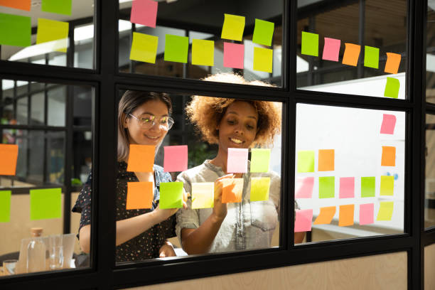 istock Multi racial businesswomen writing on sticky notes new startup ideas 1181590460