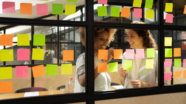 istock Friendly mates discuss business ideas writing its on sticky notes 1181590464