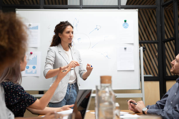 istock Female business coach makes presentation for staff 1181590474
