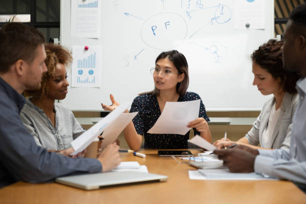 istock Multiethnic team led by asian ceo discussing financial statistics 1181590485